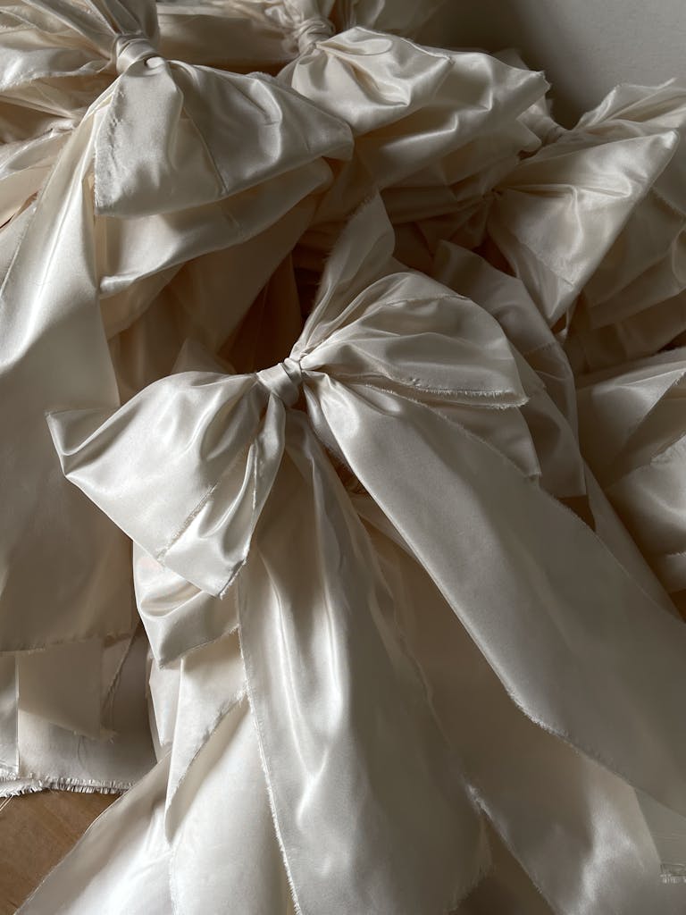 Close-up of delicate ecru silk bows arranged in a vertical composition.