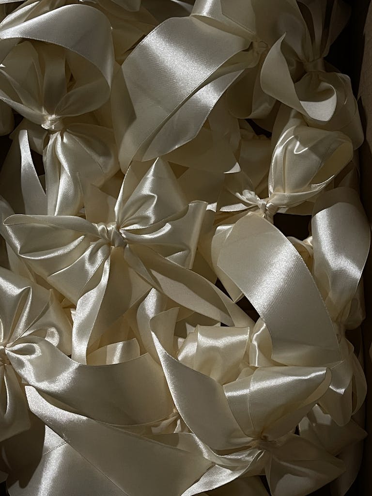 Luxurious ecru silk ribbons arranged elegantly, perfect for festive decorations.